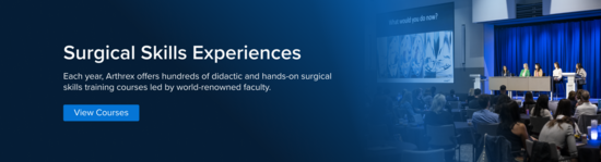 A panel of female health care practitioners speak to crowd seated at tables within an auditorium.