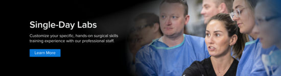 An Arthrex Clinical Specialist wearing black scrubs teaches several health care practitioners dressed in blue surgical gowns.