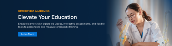 A healthcare student sitting at a desk with a book and an anatomic model studying orthopedics.