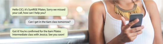 cropped view of person holding phone and a message thread on the side asking to book a class using Messenger AI